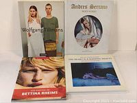 Front view of all four books showing covers and titles: Wolfgang Tillmans, Andres Serrano Holy Works, Bettina Rheims, The Heart Is a Sleeping Beauty.