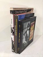 Three photography books standing, showing spine titles: 'One Man's Eye', 'La Grande Parade Portrait de l'artiste en clown', and a third book with a circus image on cover.