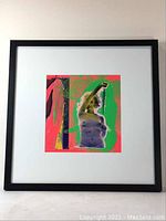 Framed psychedelic silkscreen of Marilyn Monroe centered on white mat in black frame, approximately 21" x 21" overall.