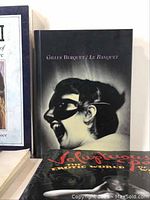 Photo showing the cover of 'Le Banquet' by Gilles Berquet featuring a black-and-white image of a woman wearing a mask.