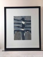 Full view of framed abstract lithograph with black frame and white matting.