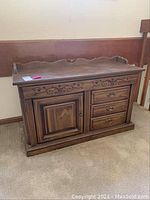 Front view of wooden Sound Design console showing carved drawer fronts and cabinet doors.