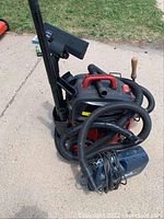 Full view of two vacuum cleaners, Craftsman wet/dry vacuum with hose and accessories visible, black vacuum cleaner partially visible behind.