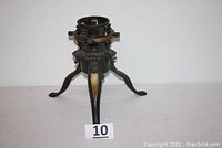 Front view of the antique cast iron Christmas tree stand showing the three legs and adjustable collar.