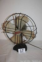 Front view of vintage Spartan oscillating electric fan showing metal blades, wire cage, and base with power cord.