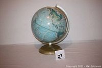 Front view of vintage Rand McNally world globe on metal stand, showing full globe and base with auction lot number 27.
