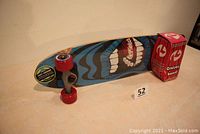 Oblique bottom and wheels view showing graphics and red wheels with packaging