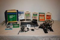 Overview of the TI-99/4A computer setup including the console, manuals, software and cables arranged on a table.