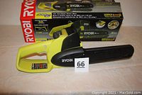 Ryobi cordless 10 inch chainsaw cutting unit with blade guard and box shown in background.