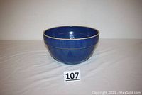 Front view of the large cobalt blue mixing bowl with number 107 card in front on white surface.