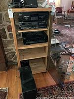 Photo of wooden shelf holding Sony cassette deck, receiver STR-D590, Sony CD player, and Bose Acoustimass bass module on floor.