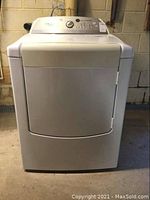 Front view of white Whirlpool front loading electric dryer showing door and control panel.