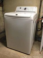 Front view of white Maytag Bravos top load washer showing overall condition and model type.