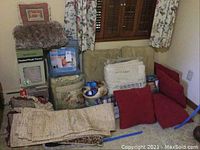 Full view of the lot showing stacked boxes of heated throws, various pillows, curtains, and other textiles.