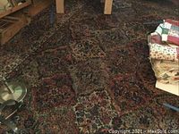 Full view of the large patterned area rug on floor surrounded by furniture and fabric stacks.