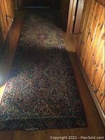 Full length view of the rug runner laid out on hardwood floor showing its rectangular shape and intricate patterned design.