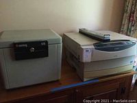Photo showing the Sentry 1170 safe, Canon PC941 printer, and surge protector placed on a wooden surface.