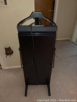 Front view of Clothes Butler valet stand showing hanging area, control panel and cord wrapped around stand.