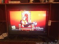 Front view of Sony Bravia 32-inch LCD television turned on, showing screen image with a person sitting on a throne.