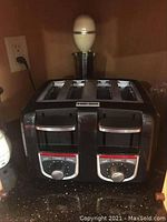 Full view of the Black & Decker 4-slice toaster with dual control dials and stainless steel finish.