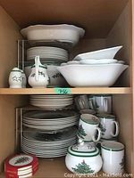 Upper and lower shelf overview showing stacks of plates, bowls, mugs, creamer, sugar bowl and salt & pepper set