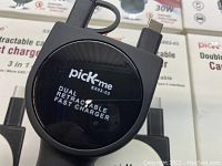 Close-up of PickMe dual retractable cable fast charger showing branding and cable connectors.