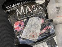 Plastic package containing a reusable washable dustproof mask with floral print visible through packaging