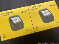 Two boxed Rexing V1 dash cams, yellow packaging, showing front with model and features including 4K and WiFi icons.