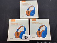 Three unopened boxes of Zamkol Kids Wireless Over-Ear Headphones in blue and orange, model ZHK00, front view with label showing number 40.