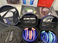 Overview of the lot showing multiple headphones in cases, Oppo Bluetooth wireless audio receiver and accessories
