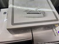 Closed white boxes showing packaging for nail dust collector table lamps.