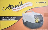 Photo of the Attwell Automatic Bubble Machine packaging with branding and product image, showing the bubble machine and bonus bubble water included.