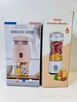 Two boxes side by side: one for Wireless Juicer in pink, blue, and white color options; one for Aitsite Portable Blender with fruit inside and 380ml capacity noted.