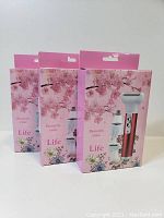 Three boxed units of the personal care mini shavers with floral pink packaging.
