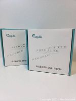 Two boxed packs of Megulla RGB LED Strip Lights showing packaging design and branding.