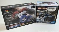 Photo of DEERC DB35 and Amphibious Stunt RC cars in their boxes, showing packaging and branding.