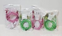 Four sealed dual chargers for Apple devices, two pink and two green, in original packaging.