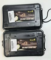 Two closed WindFire branded hard black plastic carrying cases labeled Ultra Bright Flashlight Series.