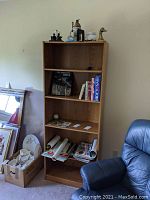Bookshelf containing various books, beer steins, ephemera, and decor items.