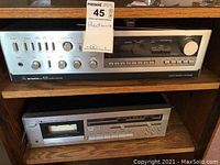 Full view of Mitsubishi DA-R25 stereo receiver on top shelf and Nakamichi 480 cassette deck below on wooden shelving