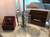 Overview photo showing wooden letter organizer on right, metal photo frame carousel center, and woven basket with reading glasses on left.