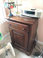 Full view of the wooden cabinet showing the drawer, door, and overall condition.