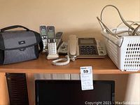 Photo of JVC camcorder carrying case with phone equipment and extension cords on table