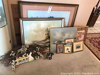 All items arranged on floor, including various framed paintings and dry floral arrangement with Happy Easter sign