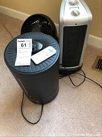 Shows the three items: a black TBI Pro humidifier with remote on top, a black Honeywell oscillating fan, and a smaller black fan.
