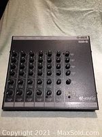 Top view of the black OZ Audio Q-Mix HM-6 headphone mixer showing six channels of rotary control knobs for volume and balance.