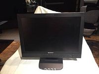 Front view of black Sony LCD monitor with screen off, on a stand.