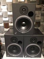 Front view of three black 20/20bas V2 speakers stacked in a pyramid