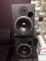 Front view of two black Event Model 20/20 passive speakers stacked, showing woofer, tweeter, and bass port