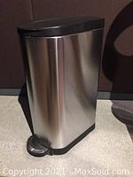 Closed large capacity stainless steel garbage pail with black lid and foot pedal